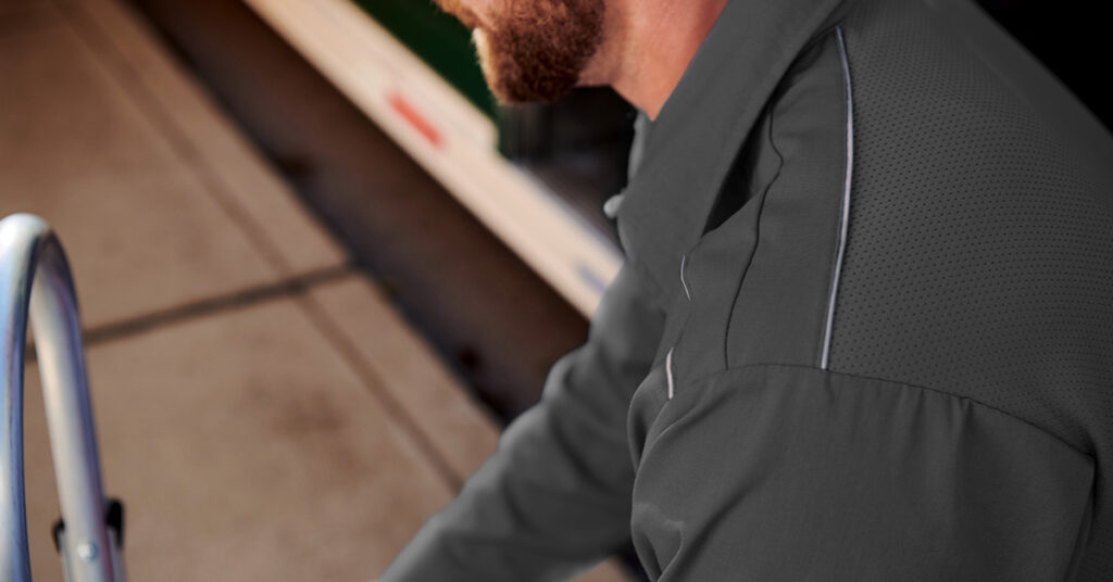 Worker in a wood shop wearing the pro airflow work shirt with a focus on the reflective striping for an added safety element