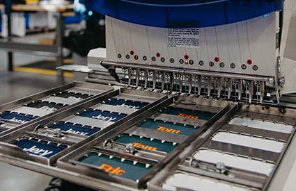 A UniFirst custom emblem machine creating emblems for a uniform rental program