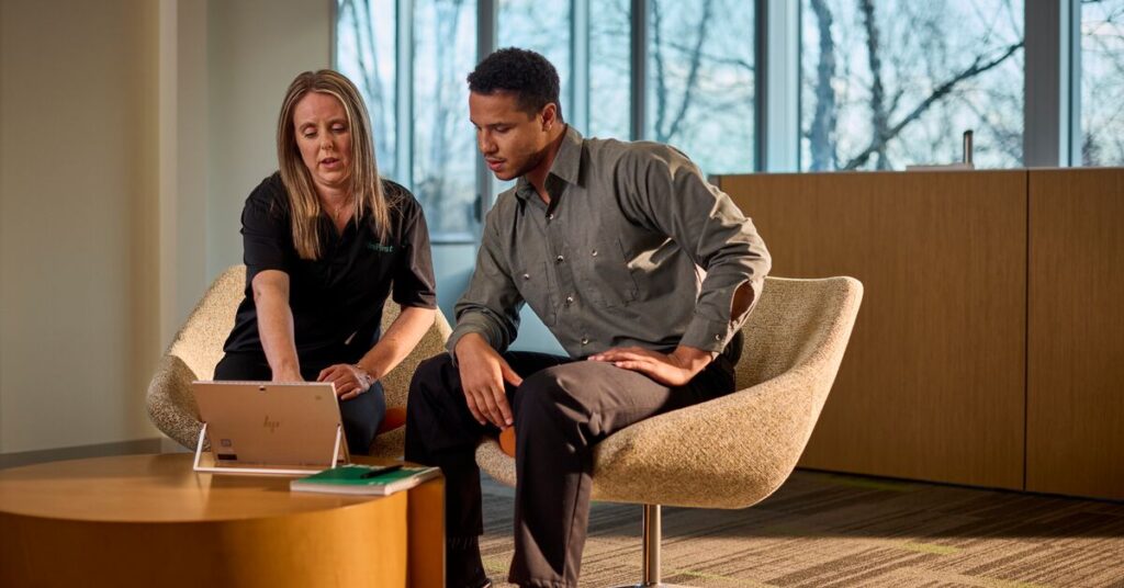 Discover the UniFirst Customer Portal – a UniFirst representative sits with a customer at a tablet