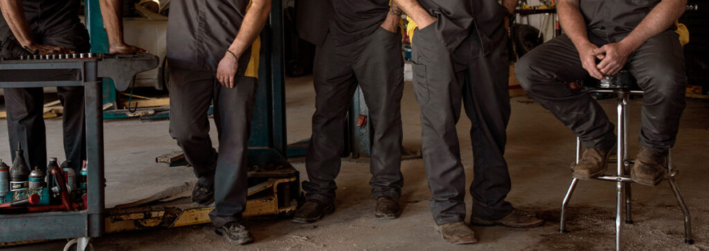 A group of automotive industry workers wearing UniFirst cargo pants.