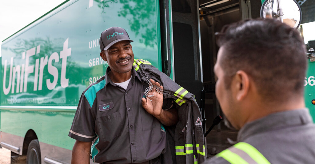 UniFirst Routes Service Representative talking with a oil and gas customer wearing industrial workwear