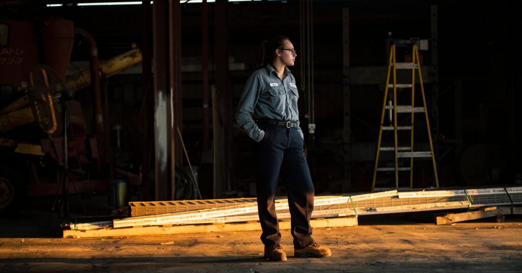 Worker in the contracting and trades industry standing alone with hands in pockets wearing safety workwear