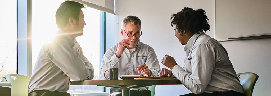 A team of workers chatting and who benefit from uniform rental services from UniFirst