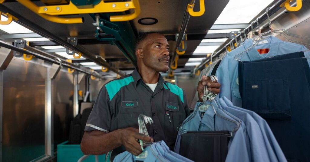 A UniFirst RSR hangs uniforms in delivery truck