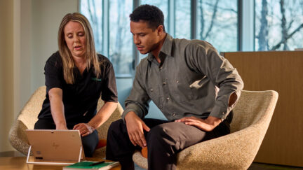 Discover the UniFirst Customer Portal – a UniFirst representative sits with a customer at a tablet