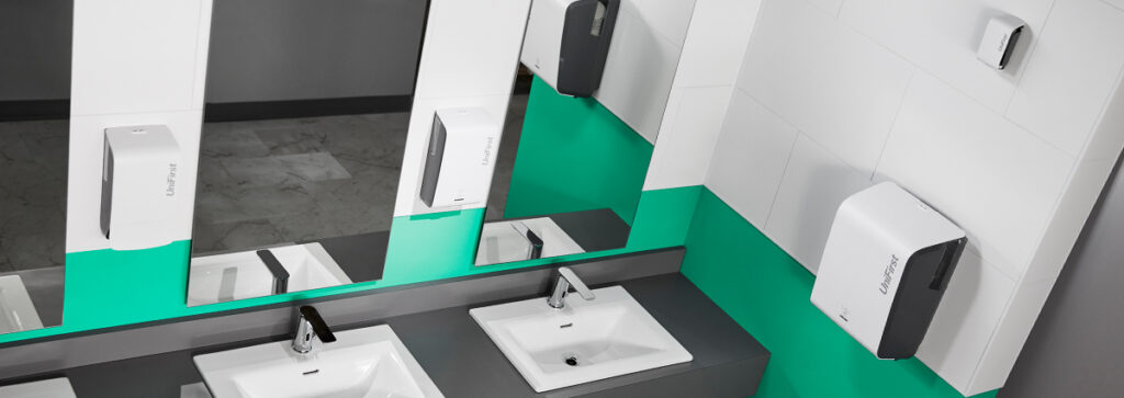 A clean public restroom featuring UniFirst Essential Series automatic air fresheners