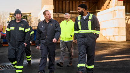 A group of workers at a work site wearing uniforms as part of a uniform rental service