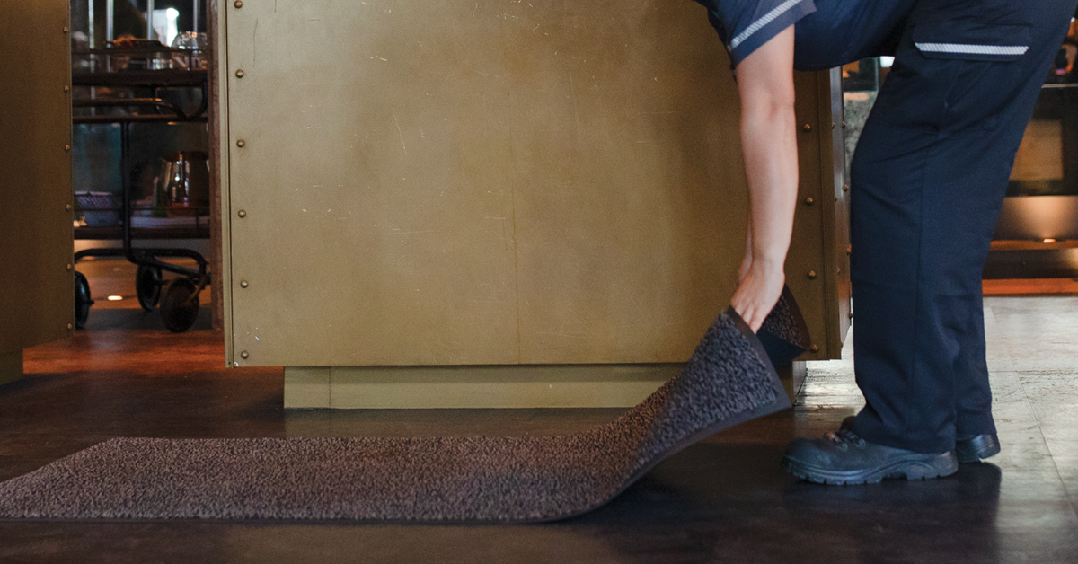 UniFirst Route Service Representative places a clean Great Impressions® 2.0 Walk-Off Mats in a local business that has a UniFirst managed facility services program.